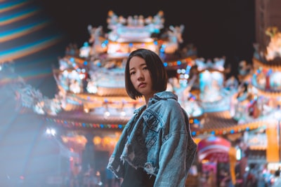 穿着蓝色牛仔夹克的女人站在商店前面